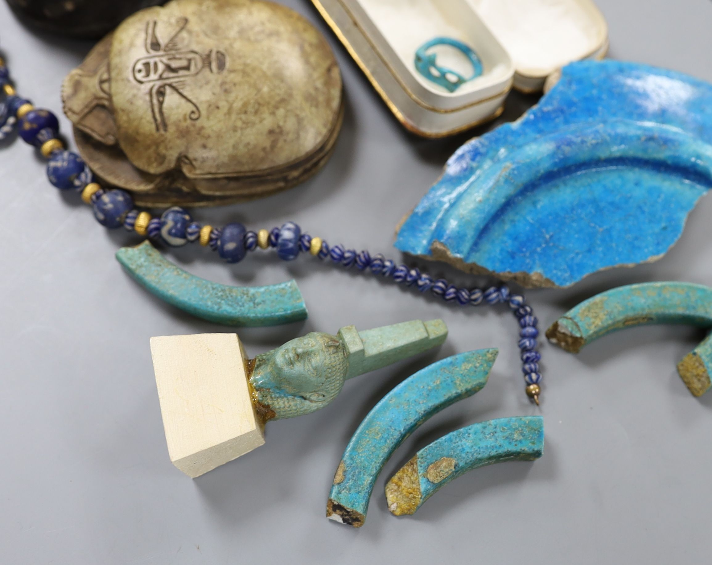 A small collection of Egyptian artefacts including necklace, scarabs, rings and a later scarab, part of the Josephine Dubois collection